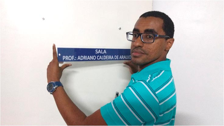 Prof. Flávio Dantas, Chefe do Departamento, coloca a placa.