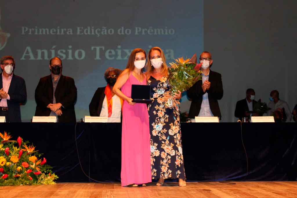 A funcionária Tatiana Carvalho de Castro recebe a placa de homenagem.